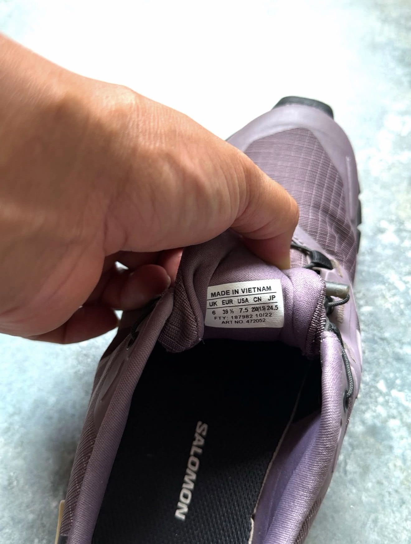 Close-up of a lavender athletic shoe tongue showing the label: MADE IN VIETNAM and size conversions (UK/EUR/USA/CN/JP).