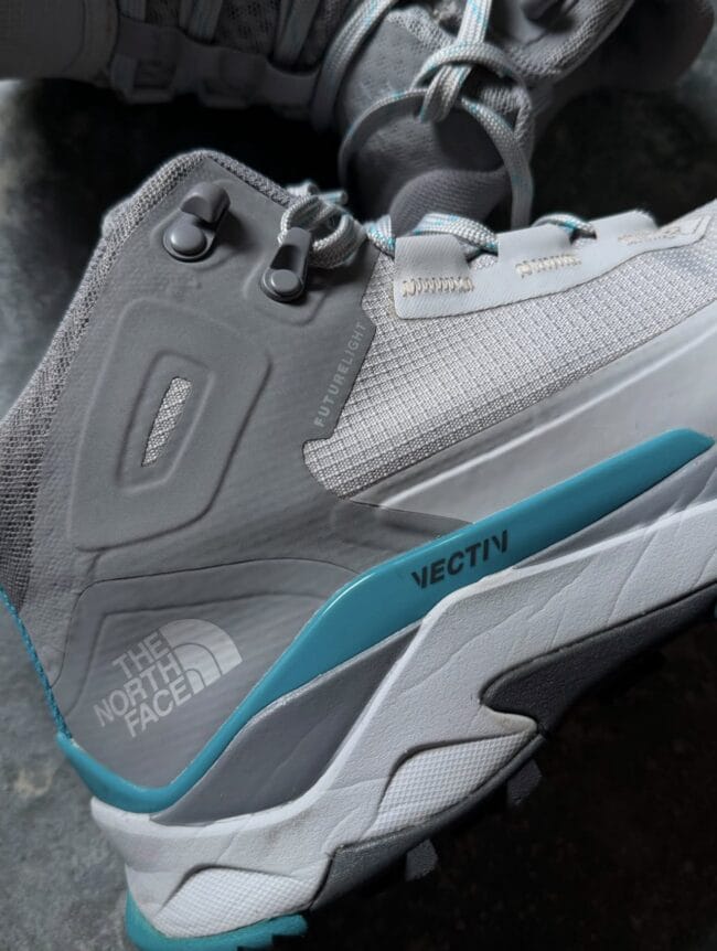 Close-up of a gray The North Face Futurelight hiking shoe, showing laces, eyelets, and teal sole detail.
