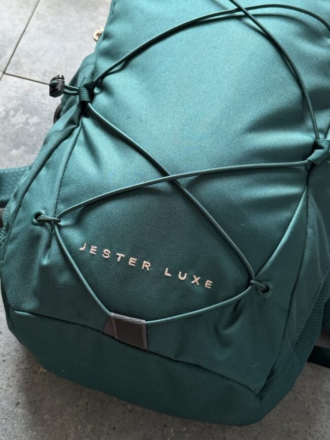 Teal backpack with multiple straps and a front pocket, showing the brand name JESTER LUXE in gold lettering.